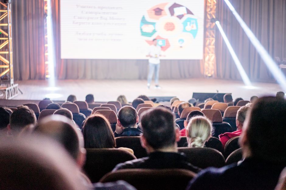 A speaker engaging with an audience in a modern conference room, representing the effective sharing of valuable case study insights.